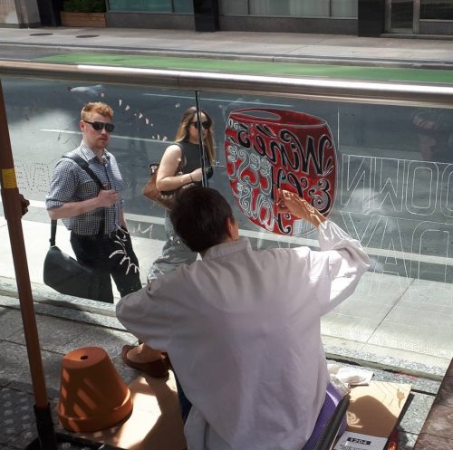 Alison Garwood-Jones painting the windows at The Merchant Tavern, Toronto